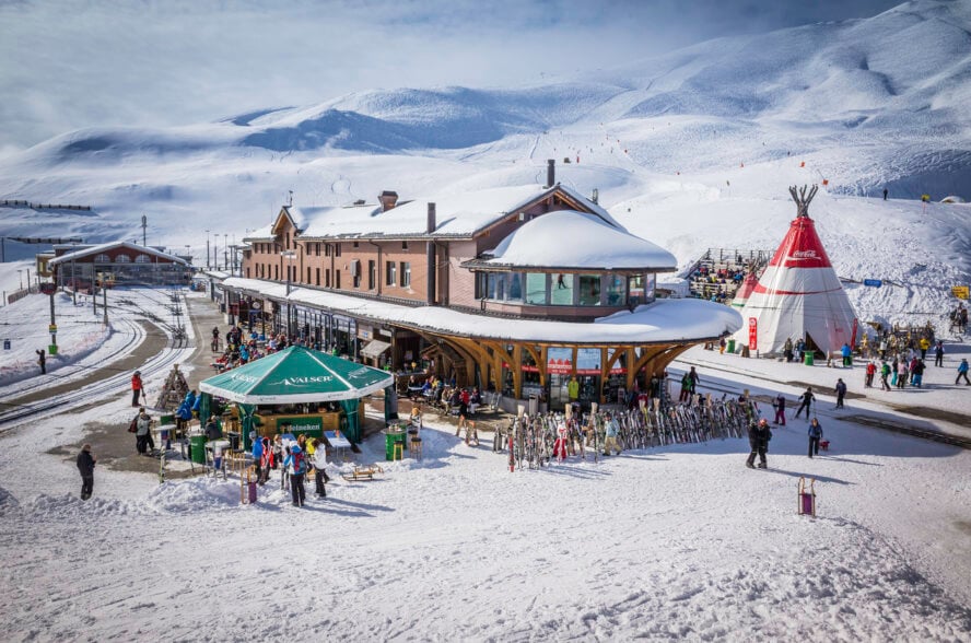 Skiers relaxing at apres ski bars in winter Alps Switzerland, the European Alps