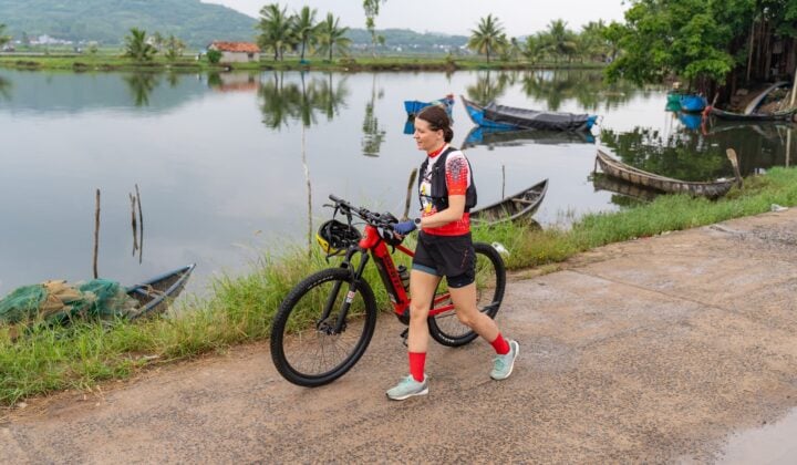 Cyclist walking near boats in Vietnam