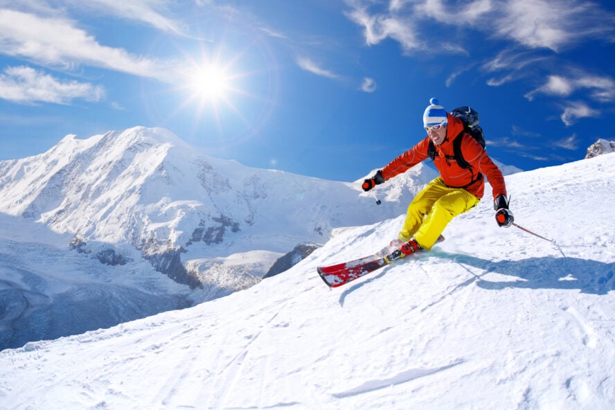 Skier skiing downhill against Matterhorn peak in Switzerland