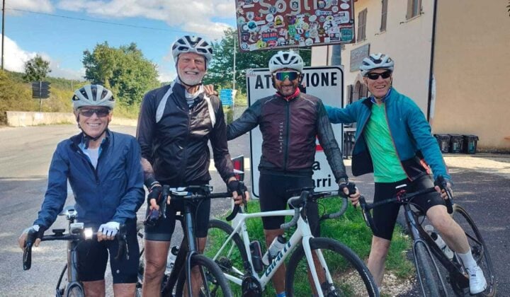 Four bikers near a sign in Italy