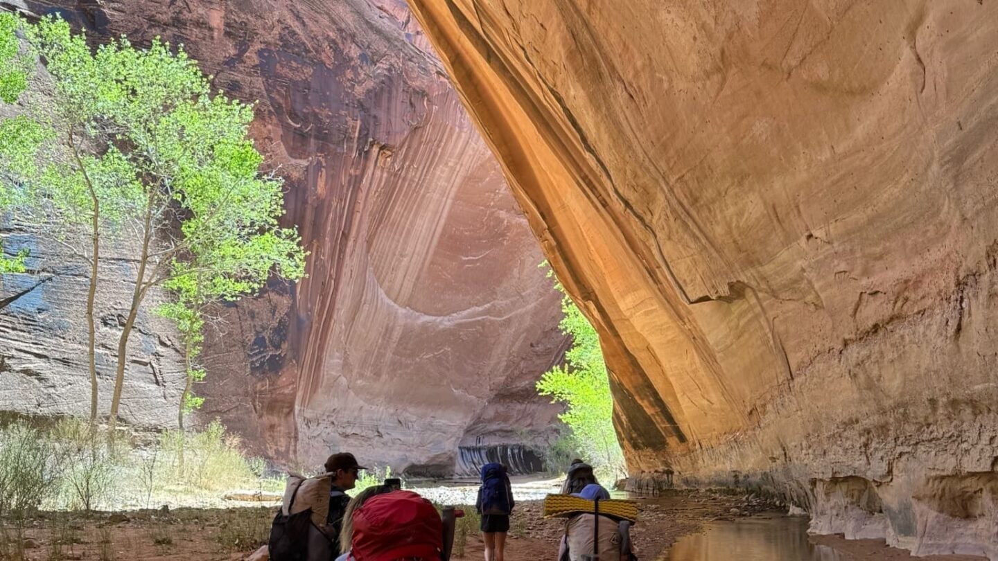 Hikers under arch in Utah