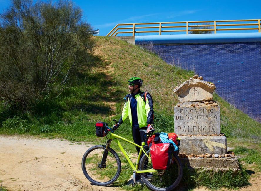 Biker near a sign on the way to Santiago
