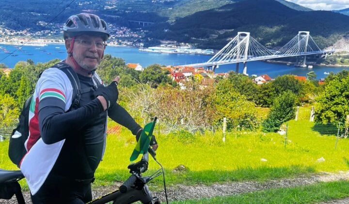 Image 6: Cyclist overlooking a coastal bridge on the route to Santiago